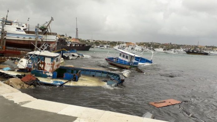 nella foto barche di migranti affondate all'interno del porto di Lampedusa