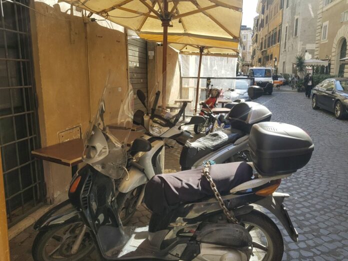 LO SPAZIO ESTERNO DI UN RISTORANTE CHIUSO NEL CENTRO DI ROMA UTILIZZATO COME PARCHEGGIO PER SCOOTER