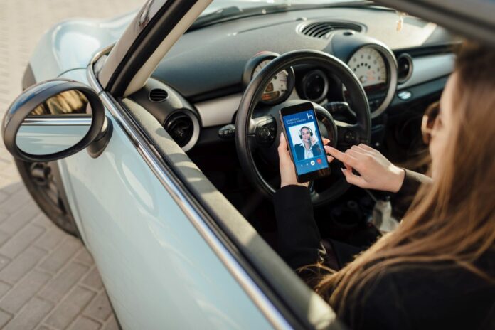 Woman in car. Girl using smartphone app to pay for the parking.