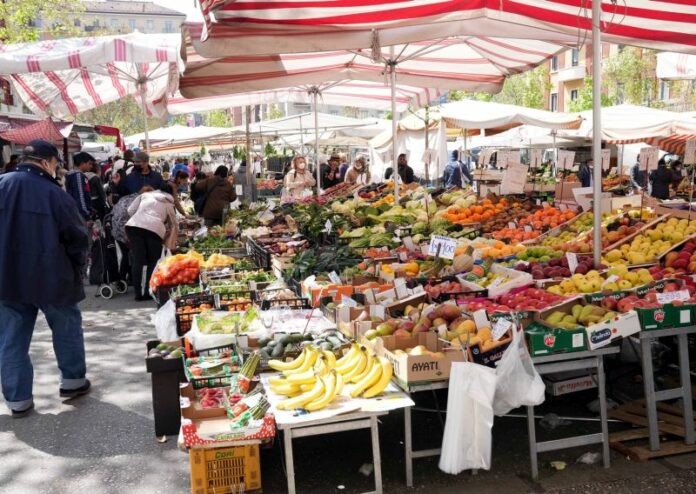 Mercato di Papiniano con poca gente e persone che rovistano negli avanzi lasciati dei venditori