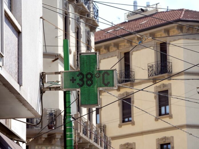 Caldo a Milano, arriva l' onda di caldo Caronte, persone con capelli o con ombrelli per proteggerse del sole, con termometri che indicano fino a 45°