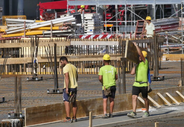 Milano, Continuano a ritmo incessante i lavori per la realizzazione del villaggio Olimpico nonostante l'arrivo del grande caldo e condizioni di lavoro molto difficili.