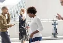 Le rimesse dei lavoratori stranieri dall’Italia all’Africa: i dati del 2025 donna africana smartphone