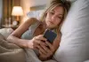 Controllate il telefono appena svegli? L’abitudine del mattino che rovina concentrazione e umore donna con smartphone appena svegliata
