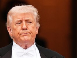 Trump ritratto con una mitragliatrice in mano: “L’Iran si dia una regolata”