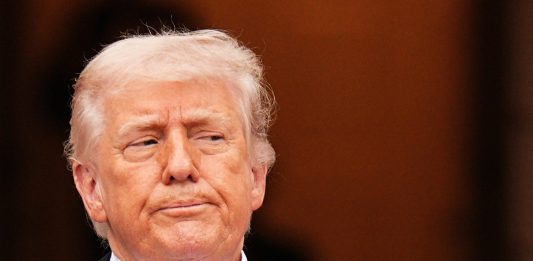 Trump ritratto con una mitragliatrice in mano: “L’Iran si dia una regolata”