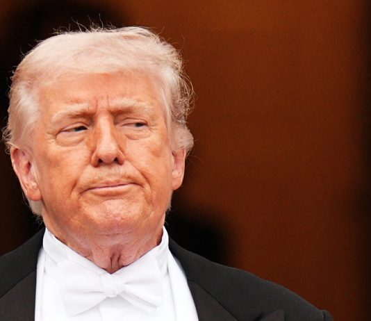 Trump ritratto con una mitragliatrice in mano: “L’Iran si dia una regolata”