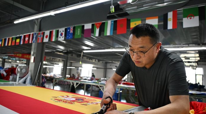 Cina: Qingdao, imprese fabbricano bandiere in vista dei Mondiali di calcio (1)