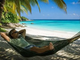 Tutti online e sempre più stanchi: il digital detox è il nuovo lusso dell’estate 2026 uomo rilassato su amaca in spiaggia